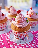 Cupcakes mit rosa Buttercreme und bunten Schokolinsen