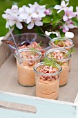 Prawn mousse in glasses on a tray in a garden