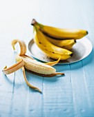 Bananenstilleben mit halb geschälter Banane