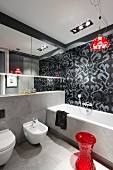 Designer bathroom in shades of grey with red accents, Campari Light pendant lamp and black and grey tiled wall with floral pattern