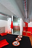 View over double bed with black bedspread into shower area in loft-style interior