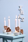 Advent candle holders made from silicone muffin cases, plaster and numbers on heart-shaped pendants