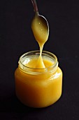 Lemon curd in a glass with a spoon