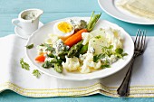 Colourful vegetables with hard boiled eggs and a herb and quark sauce