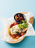 Fish in parchment paper with tomatoes, basil and olives