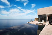 Contemporary house with encircling terrace and infinity pool with sea view