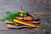 Various types of carrots on a wooden surface