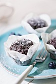 Chocolate muffins with icing sugar in paper cases