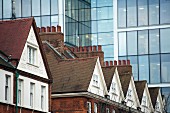 EastEnd, alte Hausdächer vor Glasfassade, London