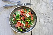 Rucolasalat mit Wassermelone, Oliven, Gurken und Schafskäse
