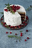 A winter cranberry cake with vanilla frosting and rosemary