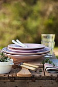 A stack of plates and cutlery outside