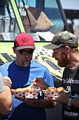 Two men eating fries at a food truck festival in California, USA