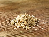 A pile of oat straw on a wooden surface