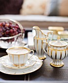 Traditional white coffee cup, sugar bowl and milk jug with gilt pattern