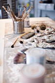 Various paintbrushes in metal holder on artist's studio table