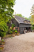 Blick über gekiestem Vorplatz auf nostalgisches Holzhaus