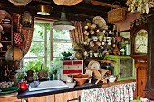 Crockery and long-case clock in vintage-style kitchen area