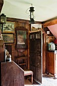 Antique pictures and old hurricane lamp in wood-panelled interior