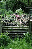 A compost heap behind a wooden fence