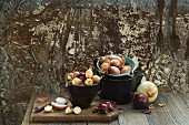 Various types of onions in bowls and chopping board