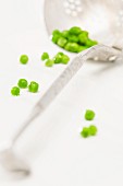 A draining spoon and peas