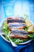 Fried sardines on lettuce with lemons