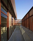 Narrow balcony of modern, Indian house with facade screened from sun by slim wooden slats