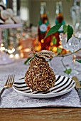 Dekorierte Birne mit Namensschildchen als weihnachtliche Tischdeko auf Schwarzweiss-Teller