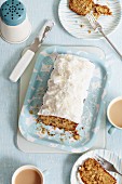 Walnut loaf cake with frosting and grated coconut, sliced