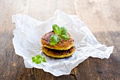 Vegetarian millet burgers with kohlrabi and herbs on a piece of paper