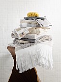 Stapel mit Spa-Textilien in Naturfarben auf einem Schichtholz-Hocker