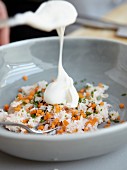 Vegetable rice being garnished with sour cream