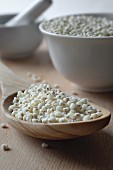 Sorghum in porcelain bowls and on a wooden spoon