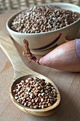 Buckwheat on a wooden spoon in front of an onion