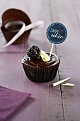 A chocolate cupcake garnished with a blackberry
