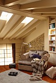 Large armchair with lustrous silver upholstery on mezzanine with delicate metal balustrade below wood-beamed ceiling