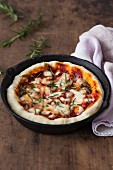 Pizza Margherita with tomatoes, Mozzarella and rosemary in a rustic pan