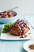 A sweet potato with red cabbage coleslaw