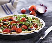 Goat's cheese tart with tomatoes, rocket, onions and olives