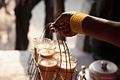A woman's hand holding a basket of freshly made morning chai