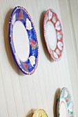 Four decorative plates with red, blue, green and yellow rims