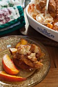 Peach cobbler in a baking dish and on a plate