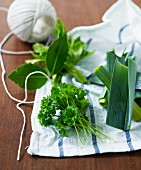Fresh herbs and leek on a tea towel