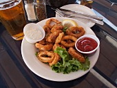 Fried, battered squid rings with dips and beer