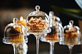 Desserts under mini glass cloches on a bar in a restaurant