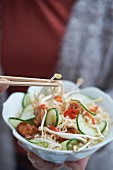 Oriental noodle soup with meatballs, cucumber and soya bean sprouts