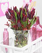 Tulpenstrauss mit dunkelroten Tulpen der Sorte Tulipa Lasting Love in Glasvase