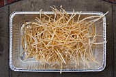 Homemade, dried fettuccine in an aluminium dish (seen from above)