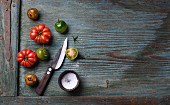 Green and red tomatoes with salt and a knife
